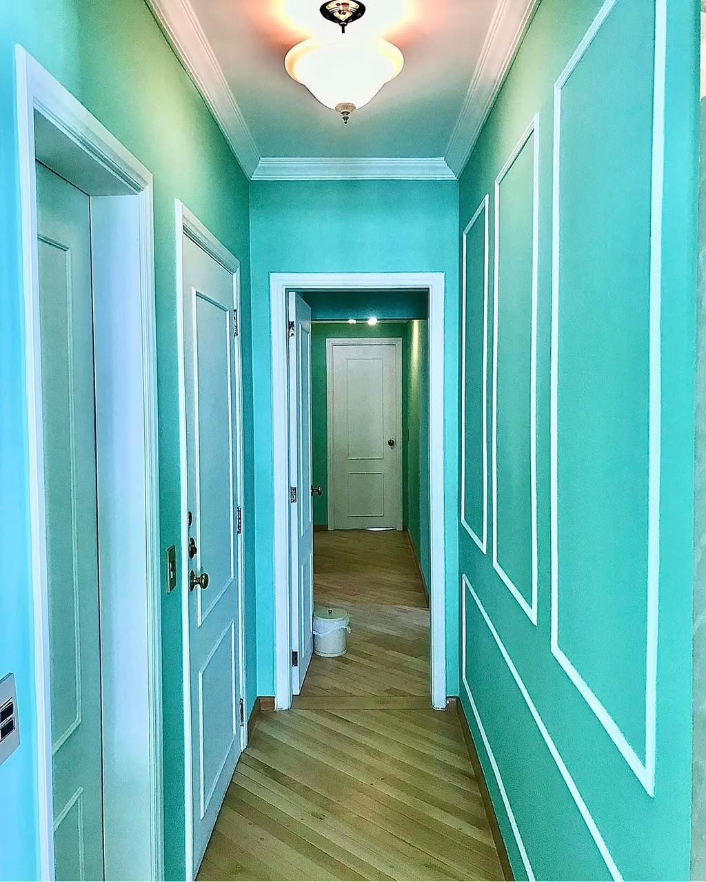 Corredor com paredes em verde e detalhes brancos